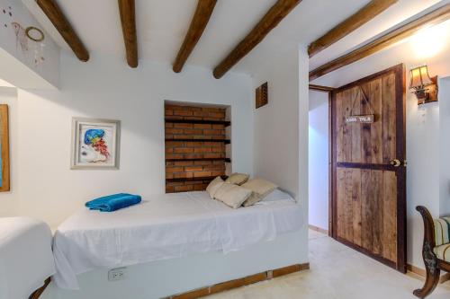 a bedroom with a bed and a brick wall at Casa Caracola in Tubará