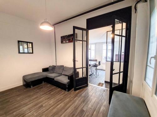 un salon avec un canapé et un miroir dans l'établissement Vincennes superbe appartement en rdc, à Vincennes