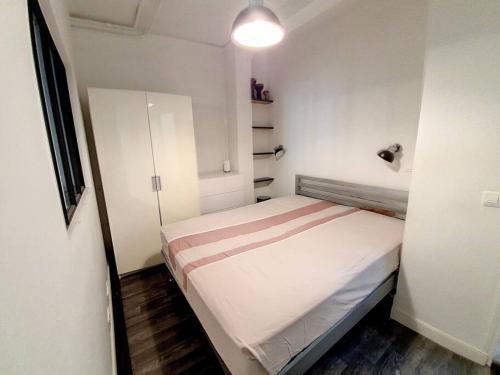 ein kleines weißes Zimmer mit einem Bett darin in der Unterkunft Vincennes superbe appartement en rdc in Vincennes