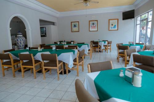ein Esszimmer mit grünen Tischen und Stühlen in der Unterkunft Hotel Zacatecas Courts in Zacatecas