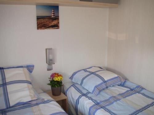 a bedroom with two beds and a picture of a lighthouse at L'alouette in Orist