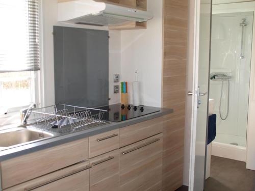 a kitchen with a sink and a shower at L'alouette in Orist