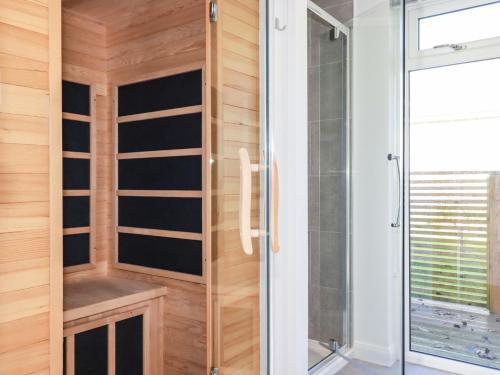 a bathroom with a shower and a glass door at 20 Meadow Retreat in Liskeard