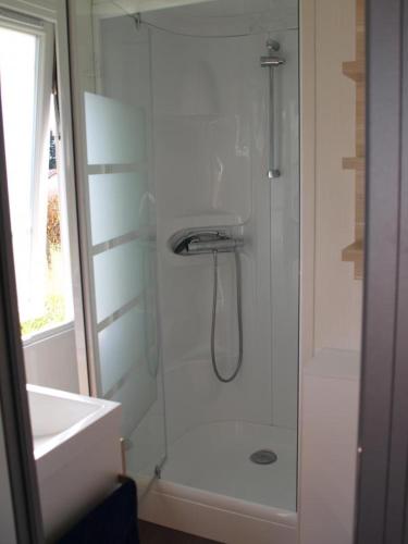 une salle de bain blanche avec une douche et un lavabo dans l'établissement La cigogne, à Orist