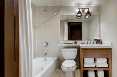 a bathroom with a toilet and a sink and a tub at Santa Fe Station Hotel & Casino in Las Vegas