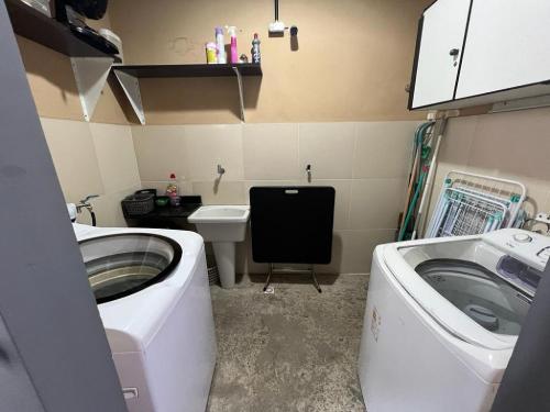 baño pequeño con lavadora y lavamanos en STUDIO 101 | WIFI 600MB | RESIDENCIAL JC, um lugar para ficar. en Belém
