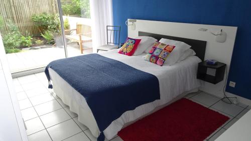 a bedroom with a bed with blue walls and a window at Escale à Lomener in Ploemeur