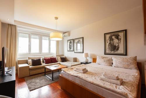 a bedroom with a large bed and a couch at Central Park Apartments in Belgrade