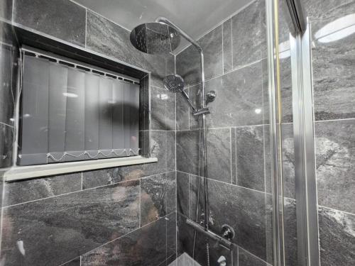 a bathroom with a shower with a glass door at 4 Bedroom 2 Bathroom Shared House - Near BHX and NEC in Birmingham
