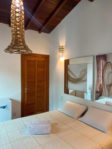 sypialnia z łóżkiem z dużym lustrem w obiekcie Pousada Casa Mucugê w mieście Porto Seguro