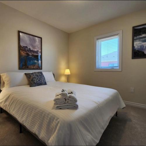 um quarto com uma cama com toalhas em New Niagara Retreat - Entire Home, 15 min drive to Falls, Sleeps 9, 4BDR em Thorold