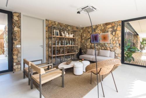 a living room with a stone wall at Pousada Maria Flor in Fernando de Noronha