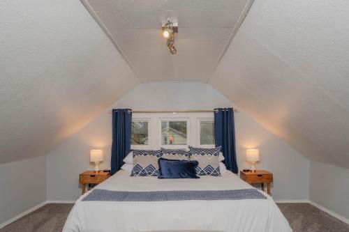 a bedroom with a bed with blue curtains and a window at Panther in Oshkosh
