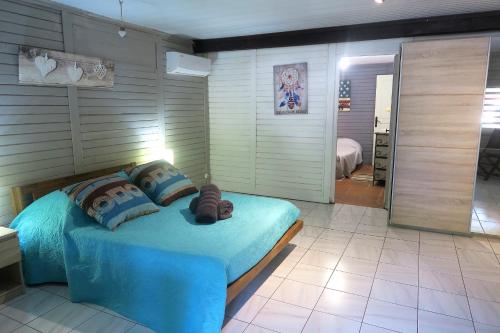 ein Schlafzimmer mit einem blauen Bett in einem Zimmer in der Unterkunft Ranch Black Horse in Les Trois-Îlets