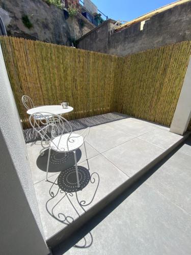 eine Terrasse mit einem Tisch und Stühlen neben einem Zaun in der Unterkunft ELISA ROOMS in Capri