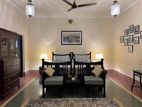 a living room with chairs and a ceiling fan at Vijai Mahal - A Colonial Homestay in Ajmer