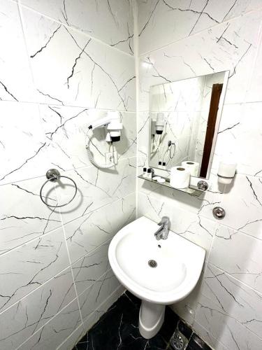 bagno bianco con lavandino e specchio di HOTEL RAYDON a Istanbul