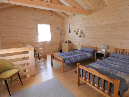 1 dormitorio con 2 camas en una cabaña de madera en La cle des champs, en Dax