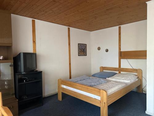 a small bedroom with a bed and a tv at Feriendorf Kimbucht in Reichendorf