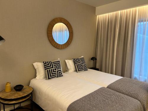 um quarto com 2 camas, um espelho e uma janela em Leça Apartments em Leça da Palmeira