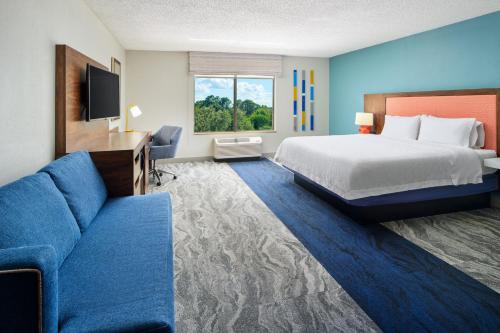 a hotel room with a bed and a couch at Hampton Inn Melbourne-Viera in Melbourne