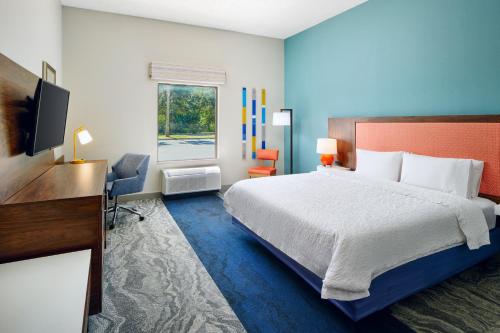 una camera con letto, scrivania e TV di Hampton Inn Melbourne-Viera a Melbourne