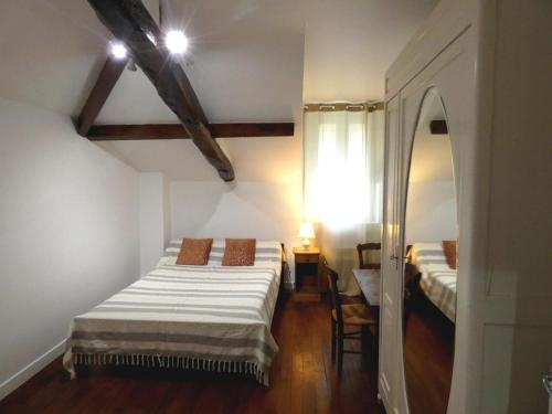 Habitación pequeña con 2 camas y espejo. en Condrine, en Saint-Cricq-Chalosse