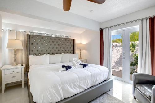 a bedroom with a large white bed with a large window at Wilton on the water courtyard and Heated Pool in Fort Lauderdale