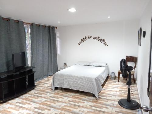 1 dormitorio con 1 cama y TV de pantalla plana en Casa de renta vacacional Andy-Cali -Valle del Cauca en Cali