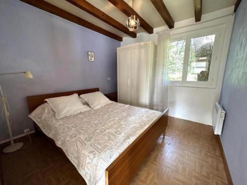 een slaapkamer met een bed in een kamer met een raam bij Le mont in Saint-Geours-de-Maremne