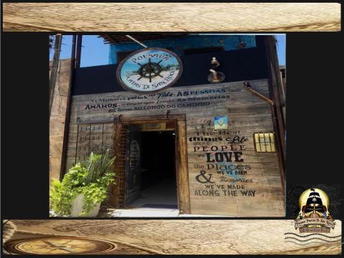 a clock on the side of a building with a doorway at Pousada Piratas Di San Rocco in Maceió