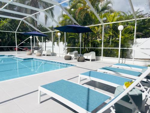 a swimming pool with chairs and umbrellas at Home in Miami in Miami