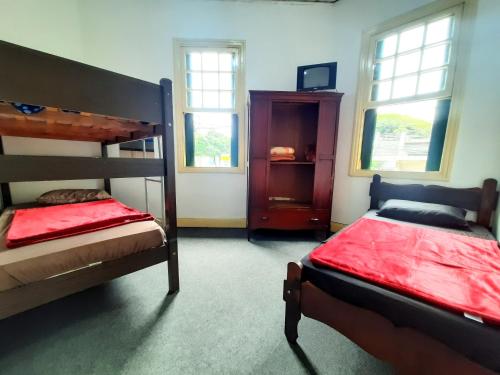 a bedroom with two bunk beds and two windows at Sétimo Hostel 7 in Sao Paulo