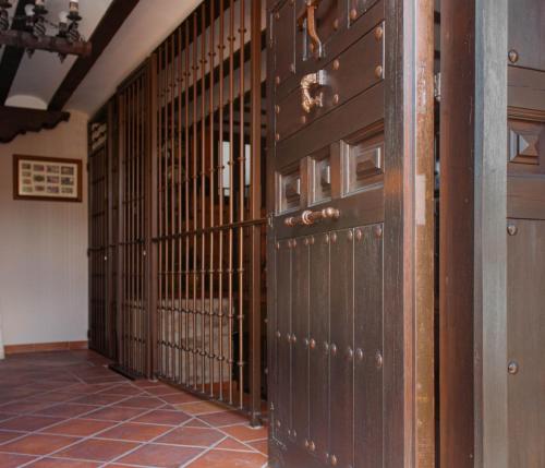 un pasillo con puertas de madera en un edificio en Casa Rural LA BODEGA, ofrece cata de vino gratis en Horche