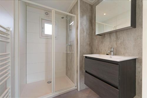 een badkamer met een wastafel en een douche bij Chalet De strandgaper - Ouddorp - Not for companies in Ouddorp