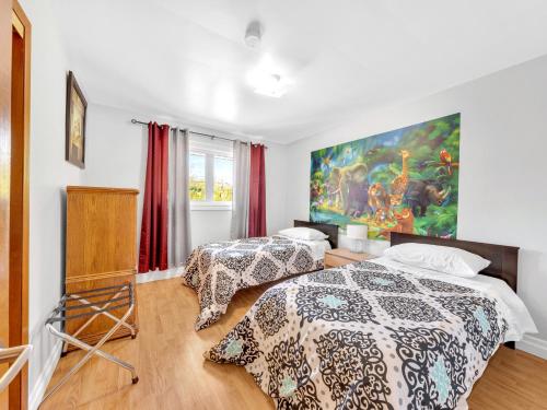 2 Betten in einem Zimmer mit Wandgemälde in der Unterkunft Park Bungalow - Seacliff Beach Suites in Leamington