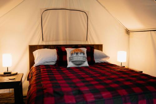 um quarto com uma cama numa tenda com 2 candeeiros em The Original Campsite on 53 acres, Branson, MO em Branson