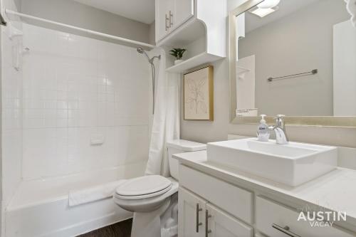 a white bathroom with a sink and a toilet at Walk to Barton Springs Spacious Apt Backyard in Austin