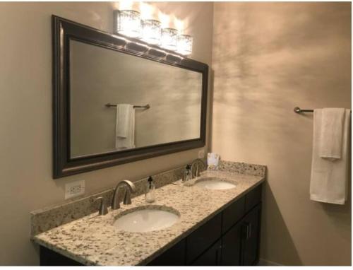 a bathroom with two sinks and a large mirror at Entire Extra Large Luxury 3 Bedrooms Condo in Washington