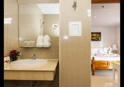 a bathroom with a sink and a bed at Patong Dynasty Royal Hotel in Patong Beach