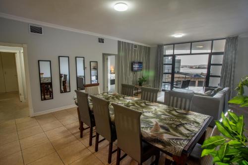 a dining room with a table and chairs and a living room at Stay at the Point - Harbour Haven in Durban