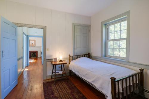 a bedroom with a bed and a table and a window at Historic Raphine Retreat Near Brownsburg Village! in Raphine