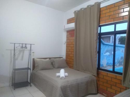 a bedroom with a bed with a white object on it at quarto 03 triplo econômico bwc exclusivo corredor in Penha