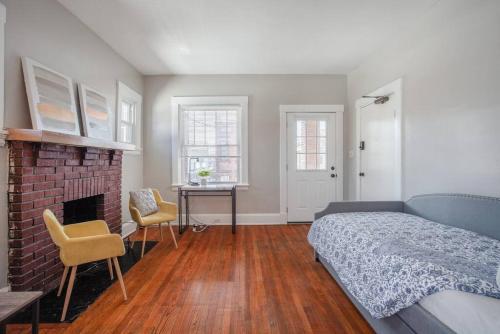 een slaapkamer met een bed en een stenen open haard bij The Villa 1B Downtown Covington by St. Elizabeth in Covington