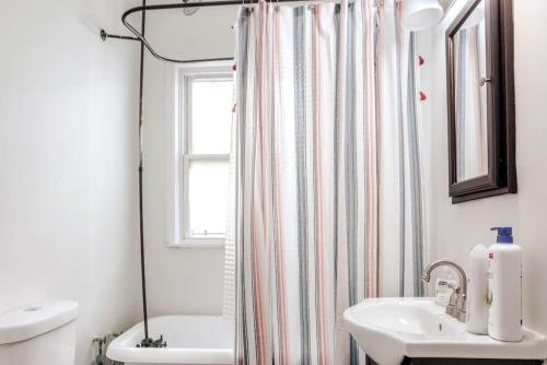 ein Bad mit einem Waschbecken und einem Duschvorhang in der Unterkunft The Villa Emerald 1B Walk to Downtown Covington in Covington