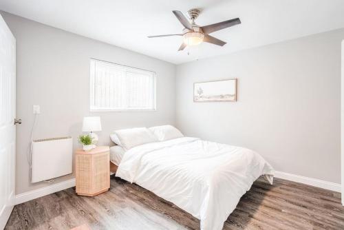 a white bedroom with a bed and a ceiling fan at Cozy, Central 1B Apt Close to UC Hospitals, DT in Bellevue