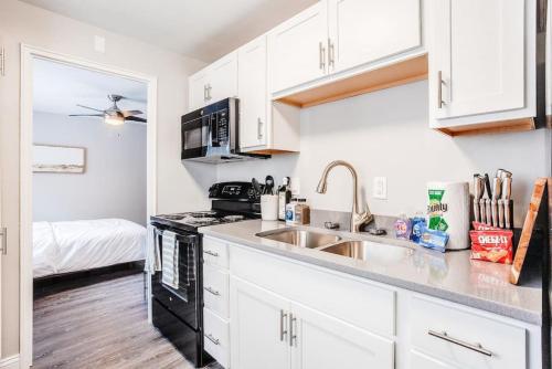 a kitchen with white cabinets and a sink at Cozy, Central 1B Apt Close to UC Hospitals, DT in Bellevue