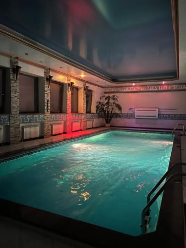 a swimming pool in a building with a lit up swimming pool at Kamelot in Kyiv