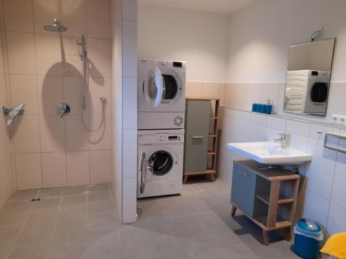 a bathroom with a washing machine and a sink at Ferienwohnung auf dem Traubshof in Ochsenhausen