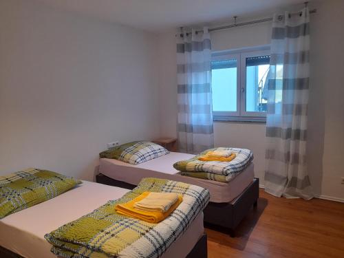 3 camas en una habitación con ventana en Ferienwohnung auf dem Traubshof en Ochsenhausen